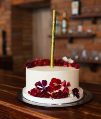 Elegant White Celebration Cake Decorated with Berries and Gold Sparkler