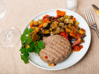 Hamburger with vegetables with stewed vegetables on table