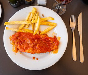 Piece of marinated fillet of white sea fish is garnished with French fries. Option of serving and serving food in cafe, restaurant, bistro