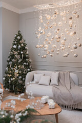 Christmas tree in living room which is decorated with garlands and silver, golden balls.