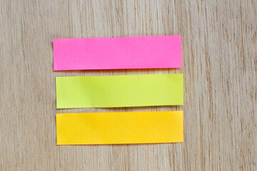 Colorful sticky page markers on wooden background.