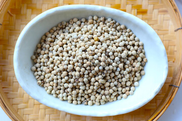 White peppercorns, used to add sharp, lasting heat and aroma to dishes.