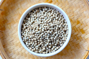 White peppercorns, used to add sharp, lasting heat and aroma to dishes.
