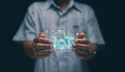 Internet of things concept. Human hands holding a glowing digital IoT symbol with a connected world map. Representing smart devices, global networking, data exchange and modern innovation.