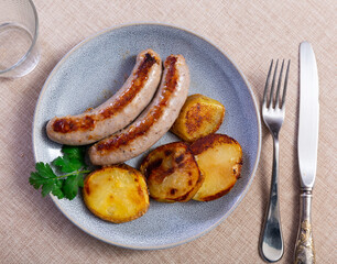 Hearty meal consists of fried sausages and potatoes. Option of serving dishes, cooking ideas for home-cooked dinner, evening parties