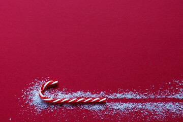 Christmas red background with lollipop stick and snow, copy space, concept, minimalism