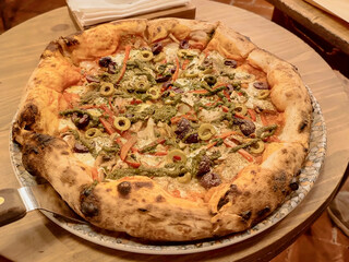 Exquisite and enticing pizza, hand-prepared and baked in a traditional oven with meat, ham, olives, and mozzarella cheese