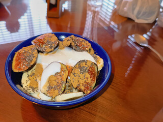Fresh fruit salad in a blue bowl, side view. Photography of healthy and delicious food.