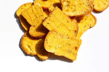 Crispy garlic bread slices on white background.