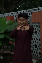 Fototapeta premium Cheerful Young Man with Pointing Finger Gesturing at Camera Outdoors Portrait