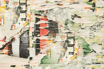 Layered street posters with torn edges revealing vibrant colors, gritty surfaces. Weathered street...