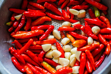 A vibrant mix of red chili peppers and garlic cloves, perfect for adding a spicy kick and savory flavor to any culinary creation. Ideal for food photography or recipe illustrations.
