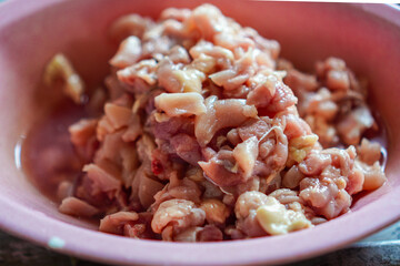 Close-up shows diced poultry in a pink bowl. The image conveys preparation for a homemade meal, appealing to culinary enthusiasts and those who value the process of creating nourishing food.