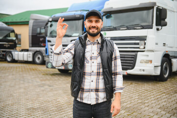 Happy truck driver showing ok gesture at depot