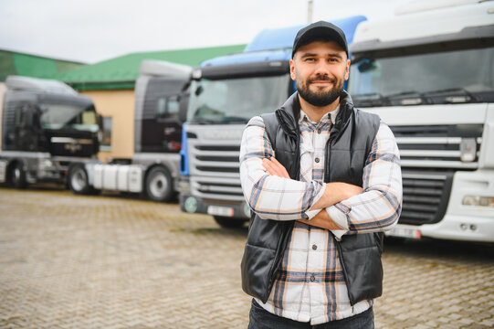 Confident truck driver standing in front of transport fleet