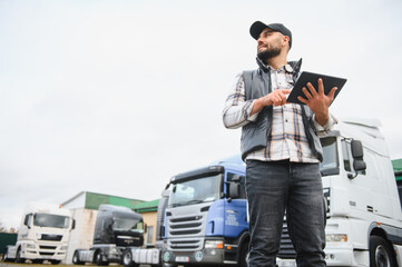 Truck driver checking logistics using digital tablet