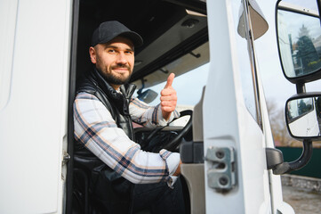 Truck driver smiling and giving thumbs up in cabin