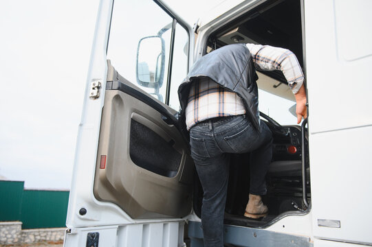 Truck driver entering semi truck cabin for work