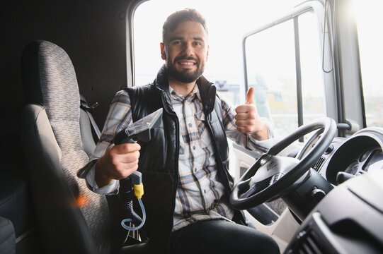 Truck driver cleaning cabin interior smiling and showing thumbs up - Powered by Adobe