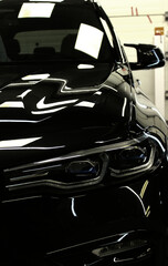 Light reflections on the glossy deep lacquer of a black car detailed stock photo