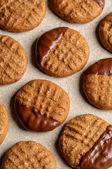 Homemade cookies made with natural integral peanut butter and chocolate. Vertical image, beige background.