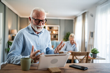 Senior man having video call on tablet at home