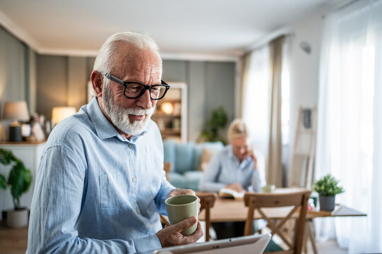 Senior man using digital tablet at home