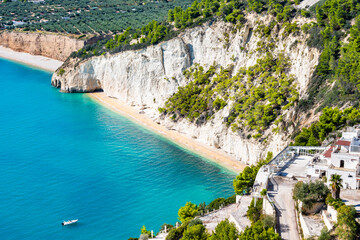 Turquoise sea and white cliffs forming a secluded Zagare beach along the Gargano coast, Apulia, Italy