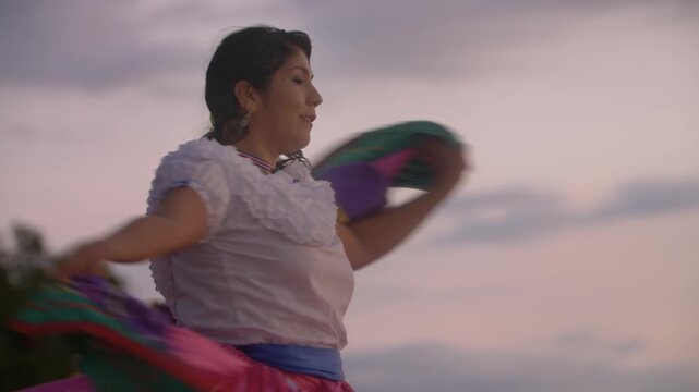Slow motion video of Costa Rican woman in traditional Guanacaste dress dancing in sunset light at the beach