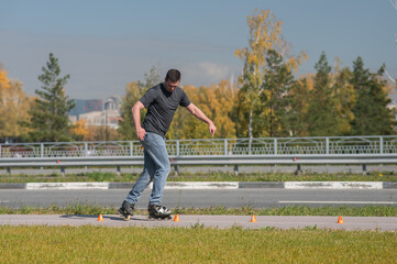 A Caucasian man rollerblades around the slalom course.