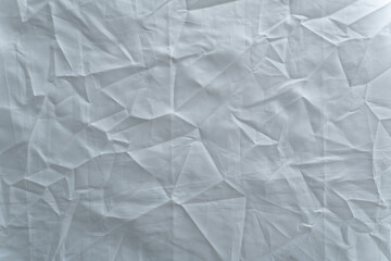texture captures the full frame of a crumpled white synthetic textile, light and shadow across the textured background.
