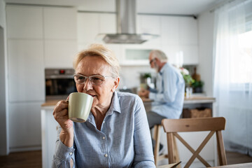 Senior woman drinking coffee enjoying domestic kitchen morning