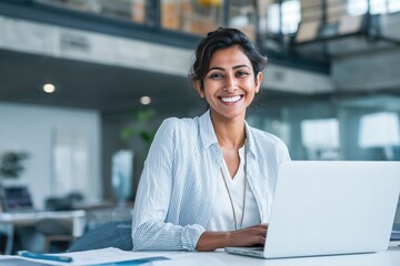 middle eastern woman working on her laptop, focused at work, corporate environment