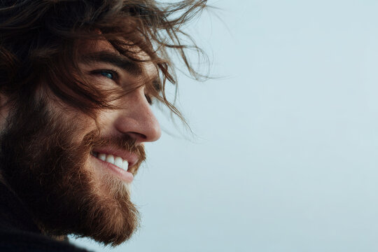 closeup of bearded man face exuding emotion and effort while smiling broadly