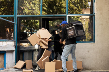 Shocked client opens her front door as the courier drops takeaway pizza order. The cardboard boxes hit the floor and the worker stumbles to avoid the misfortune, service failure.