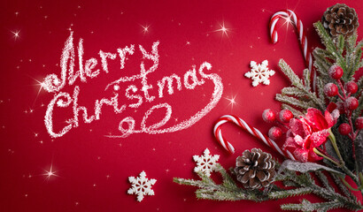 Merry Christmas red background with decorative poinsettia, fir branch and snowflakes, candy canes and cones for tree decoraton. Winter holiday congratulation card with decor.