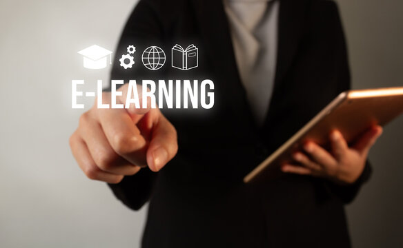 A woman is pointing at a tablet with the words e-learning written on it