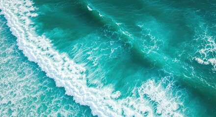 Aerial view showcases churning ocean waves with turquoise hues and foamy white crests, a dynamic display of natural power