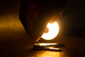 hand holding keys. man taking key to the new home. Male holding keys from new apartment. Light background. Keys concept.