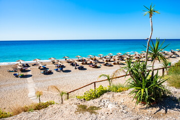 Fototapeta premium Umbrellas and sunbeds on sandy Gialos beach, Lefkada island, Greece