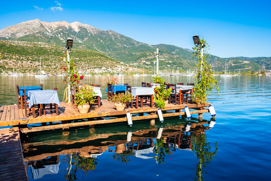 Greek taverna tables on wooden pier in Geni village, Lefkada island, Greece