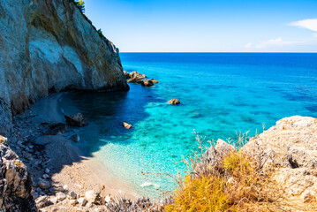 Rocks and stones in crystal clear turquoise sea water of small beach between Milos beach and Agios Nikitas village, Lefkada island, Greece