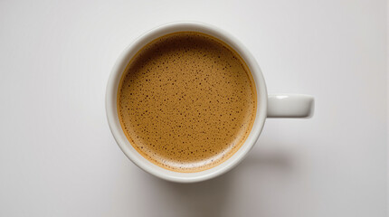 Overhead shot of a white coffee mug filled with a rich, brown espresso drink.