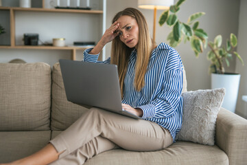 Stressed woman experiencing headache working remotely from home