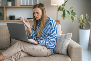 Woman experiencing technical problem with laptop during remote work