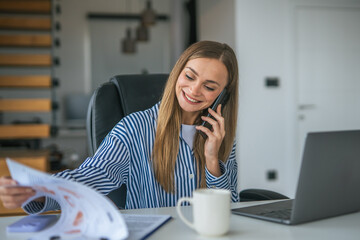 Young woman multitasking working from home on a phone call