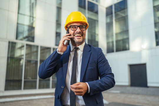 Architect or engineer in hard hat making phone call - Powered by Adobe