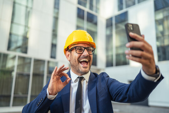 Architect man in hard hat video calling and gesturing okay