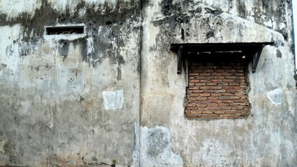 Gritty, distressed concrete wall with bricked-up window and weathered wooden awning, capturing urban decay, aged textures, and forgotten architectural details