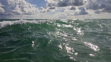 Sparkling Green Ocean Water Under Cloudy Blue Sky